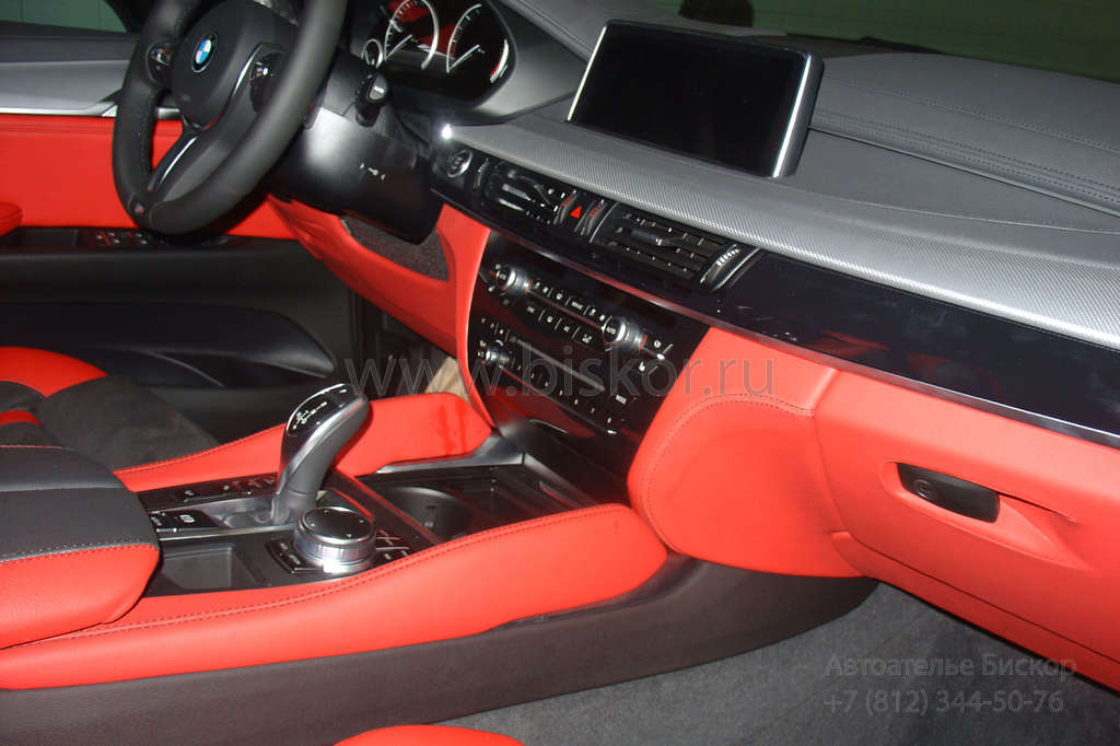 Перетяжка центральной консоли в красную кожу в автомобиле BMW X6
